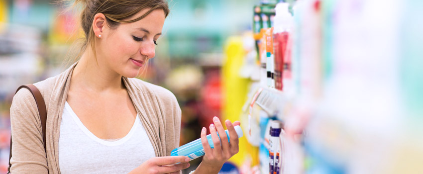 Beautiful young woman shopping in a grocery store/supermarket (color toned image)