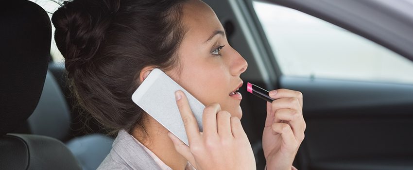 Woman having a phone call while putting on lipstick