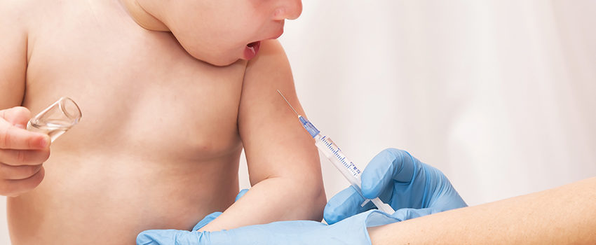 Doctor giving a child an intramuscular injection in arm