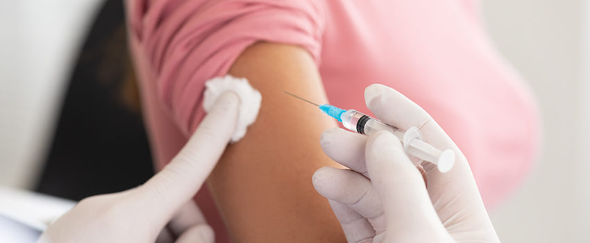 Male doctor doing vaccination to young woman