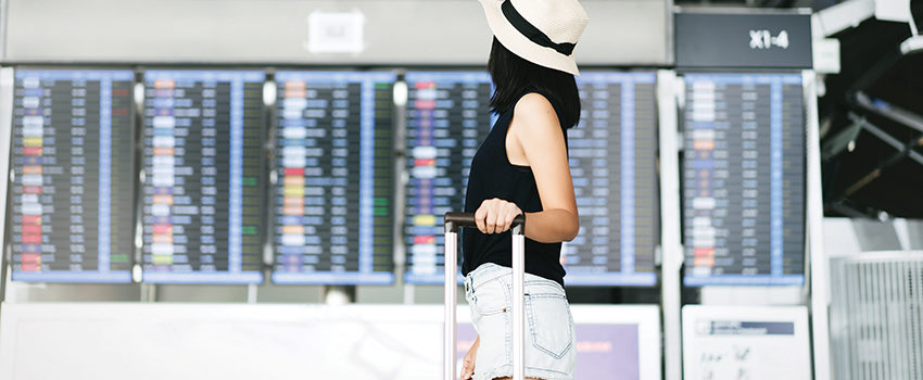 Asian adult tourist woman with travel luggage in airport termina