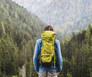 Young backpacking man traveler enjoying nature in Alps mountains